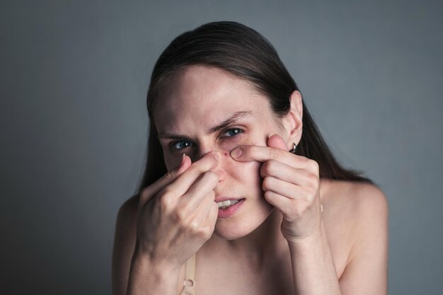 Photo portrait of young woman against gray background