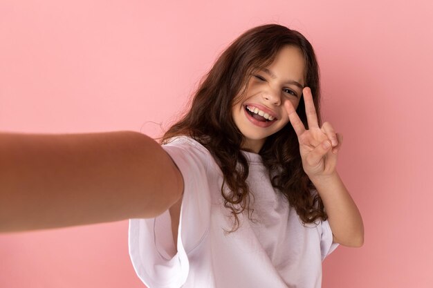 Portrait of young woman against pink background