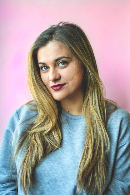 Photo portrait of young woman against pink background