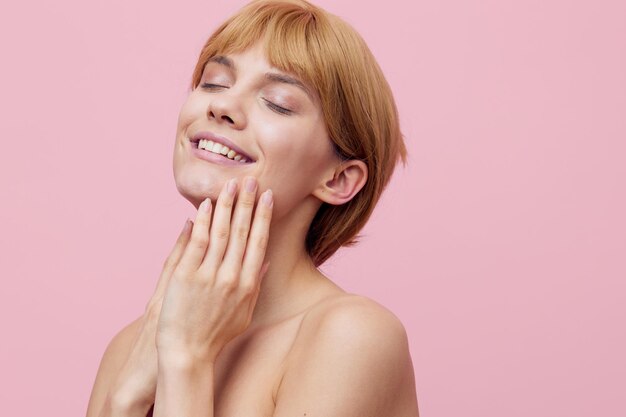 Portrait of young woman against pink background