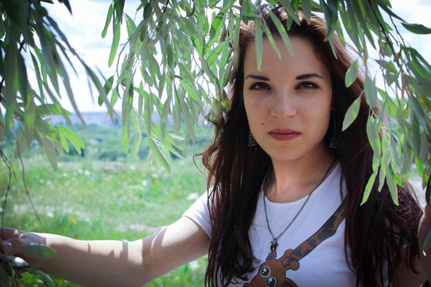 Portrait of young woman against plants