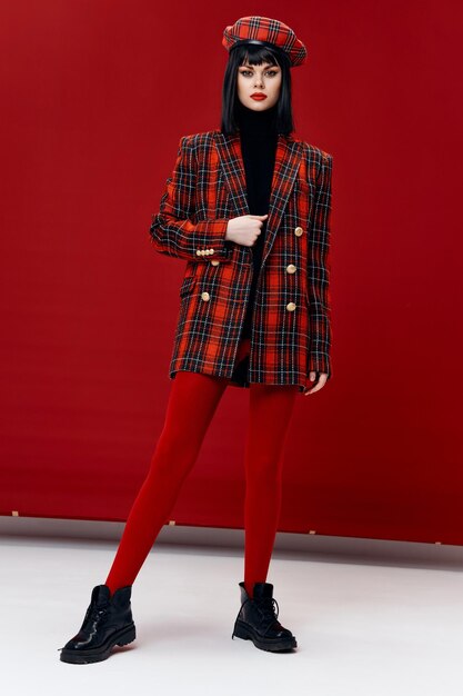 Portrait of young woman against red background