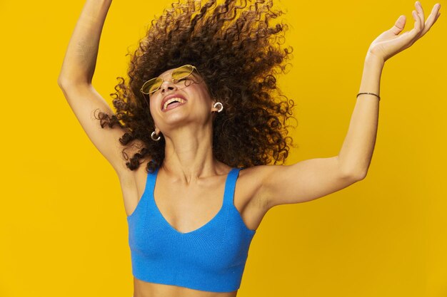 Portrait of young woman against yellow background