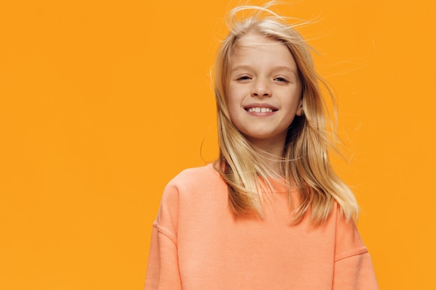 Portrait of young woman against yellow background