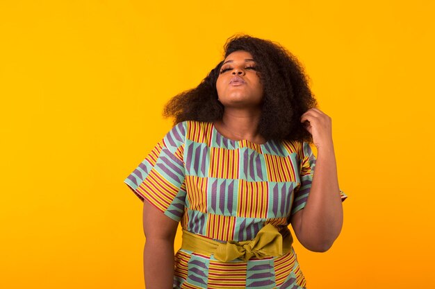 Portrait of young woman against yellow background