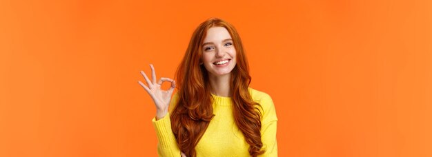 Portrait of young woman against yellow background