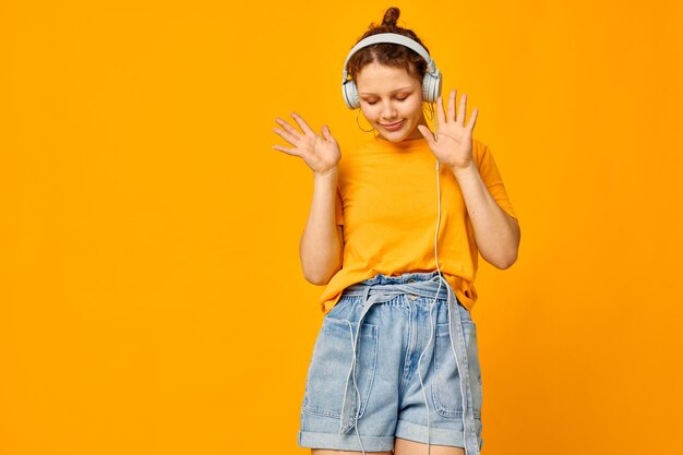 Portrait of young woman against yellow background