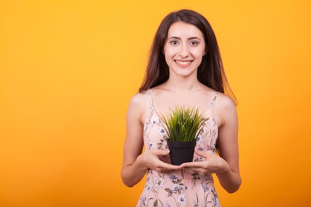 Portrait of young woman against yellow background