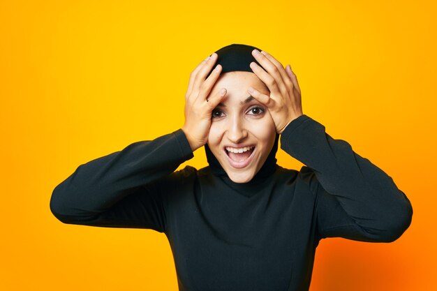 Portrait of young woman against yellow background