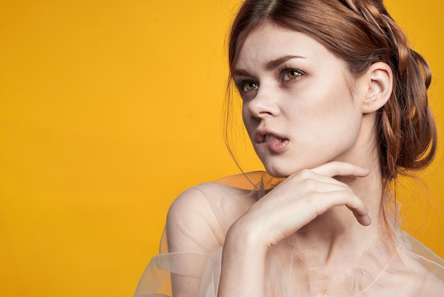 Portrait of young woman against yellow background