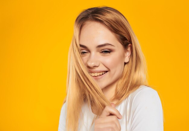 Portrait of young woman against yellow background