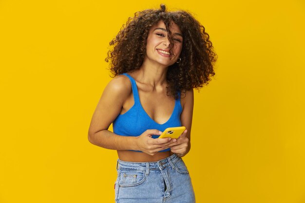 Portrait of young woman against yellow background