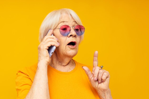 Portrait of young woman applying make-up against yellow background