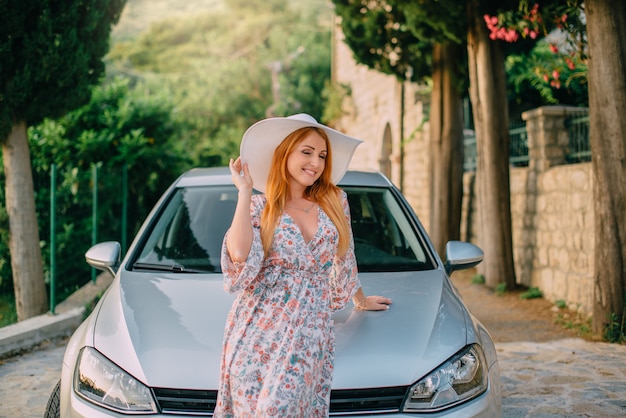 Portrait of young woman on background of modern car