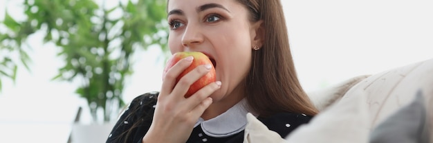 Photo portrait of young woman biting an apple