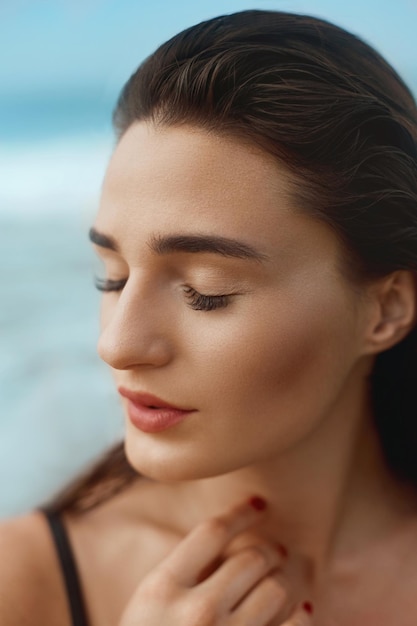 Portrait of young woman in black bikini on tropical beach looking at camera Beautiful gir