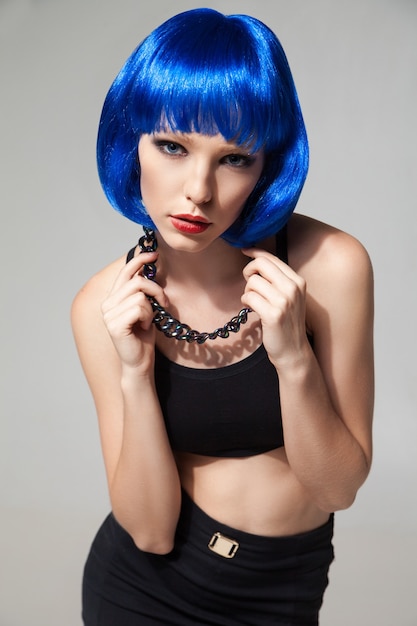 파란색 가발 머리와 카메라를 바라보는 세련된 목걸이를 한 젊은 여성의 초상화