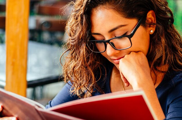 Photo portrait of young woman in book