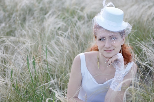 Photo portrait of a young woman. bride in white dress and hat. veil. retro style