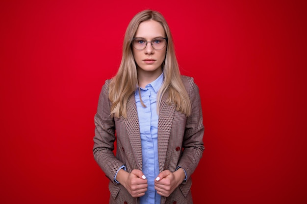 Portrait of a young woman in business clothes on a red background