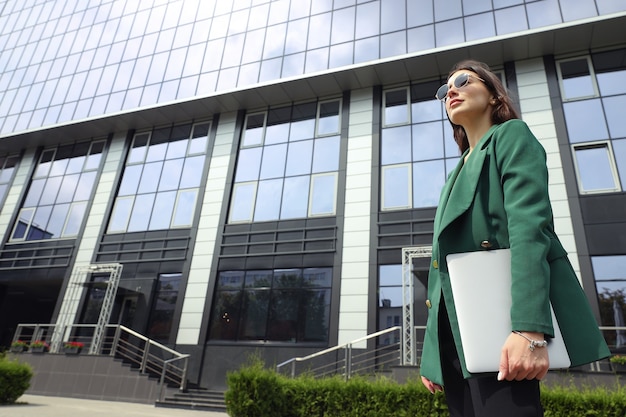 Portrait of a young woman in a business suit with a laptop