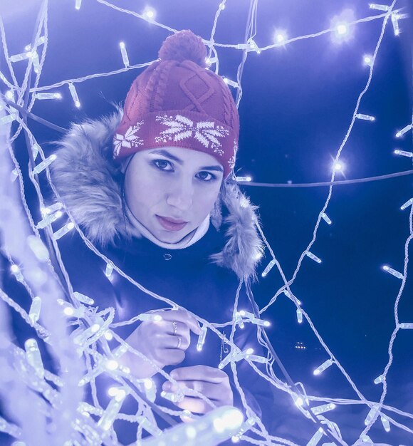 Portrait of young woman by illuminated decoration