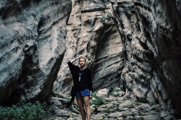 Photo portrait of a young woman by rock