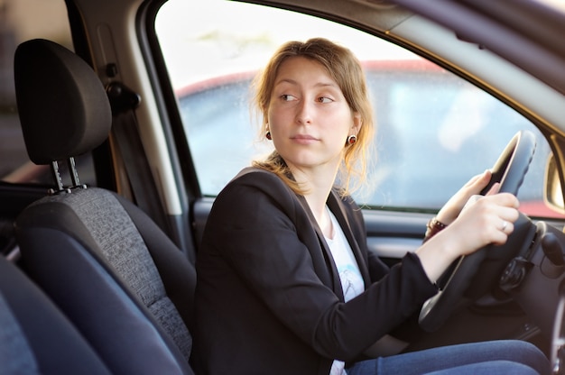 Portrait of young woman in a car