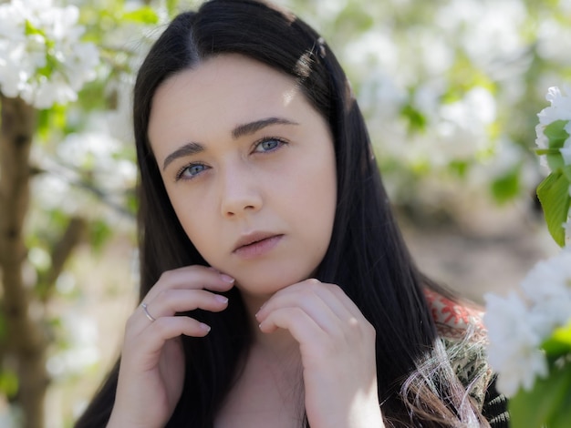 Portrait of a young woman among cherry blossoms