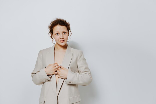 Portrait of a young woman classic suit fashion posing fun light background unaltered