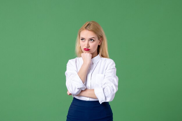 portrait of young woman in conservative clothing thinking green wall lesson school student teacher