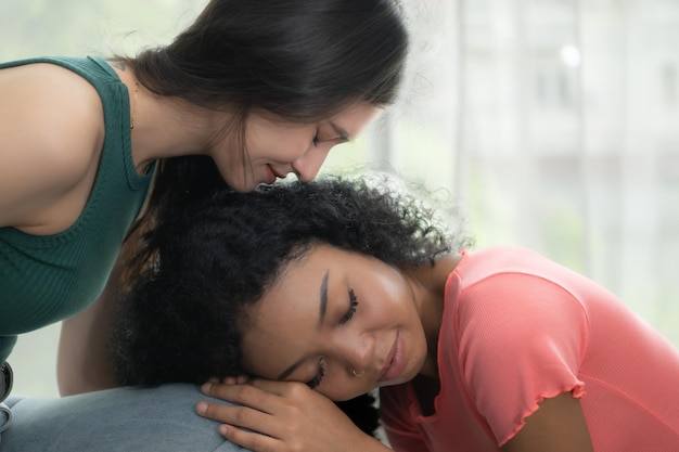 portrait of a young woman consoling her sad friend at home