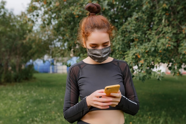 Foto ritratto di una giovane donna che copre il viso e usa un telefono cellulare