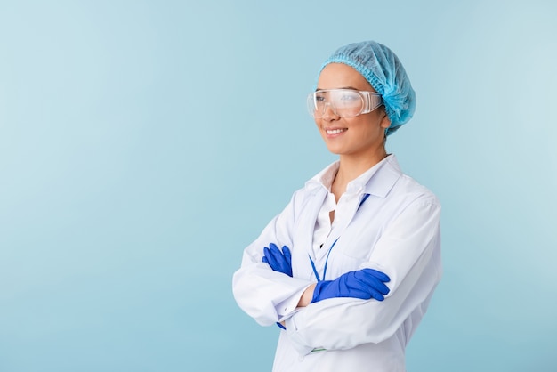 portrait of a young woman doctor posing isolated over blue wall.