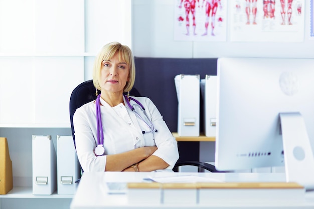 Foto ritratto di giovane donna medico in camice bianco al computer