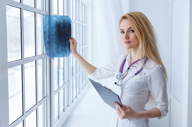 청진 기 및 엑스레이와 젊은 여자 의사의 초상화.