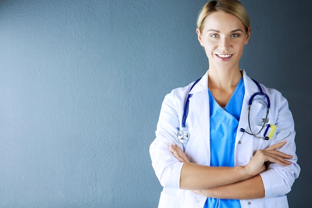 Portrait of young woman doctor with white coat standing in hospital