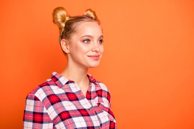 Portrait of young woman dressed in a plaid checked shirt isolated on orange