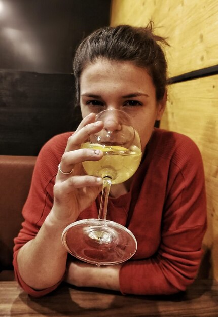 Foto ritratto di una giovane donna che beve bevande alcoliche