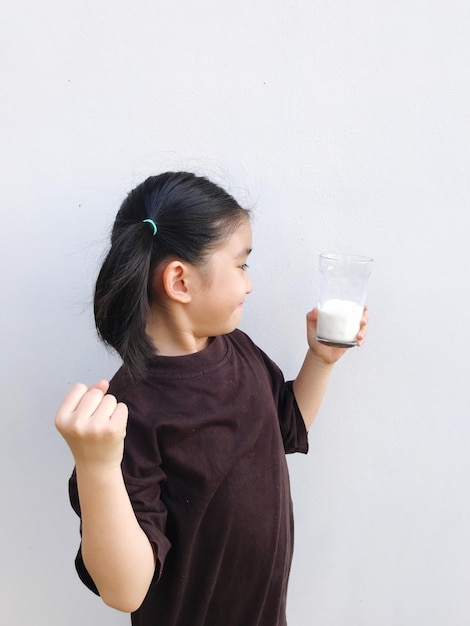 Portrait of young woman drinking coffee against white background