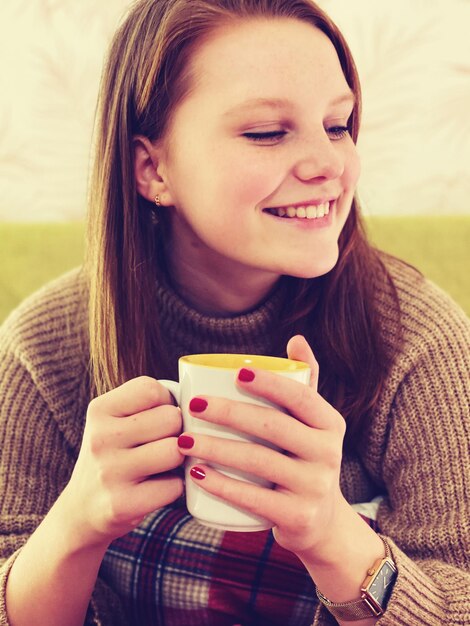 Photo portrait of a young woman drinking coffee cup