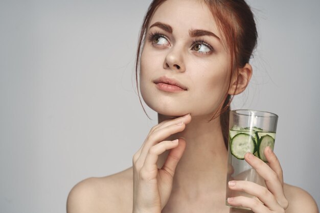 Photo portrait of young woman drinking glass against white background