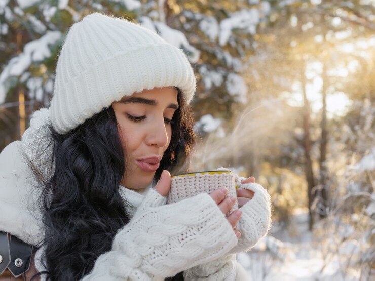 Photo portrait of young woman drinking hot drink in winter forest