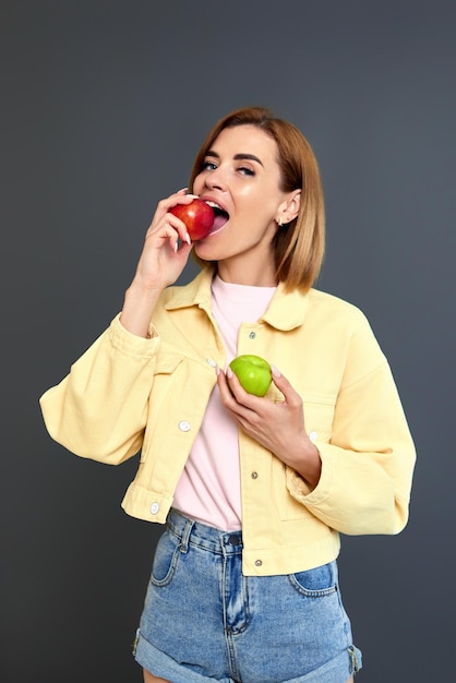 Photo portrait of young woman drinking juice against black background