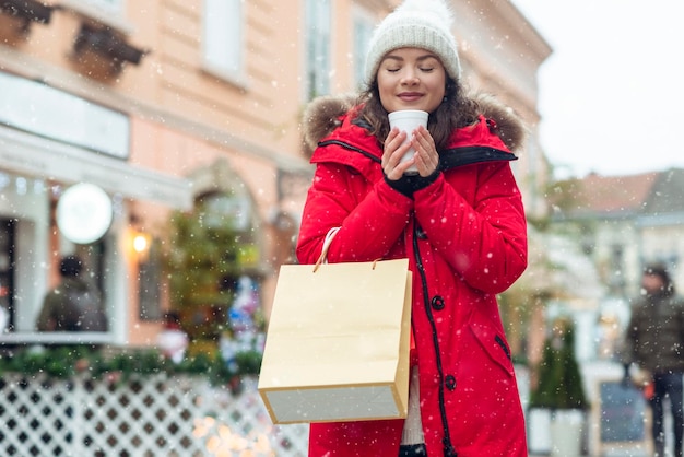 冬の街で屋外でお茶を飲む若い女性の肖像画