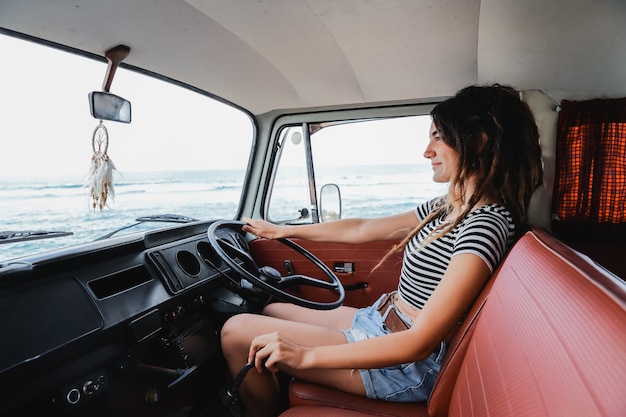 Il rilassamento del driver della giovane donna del ritratto gode del viaggio