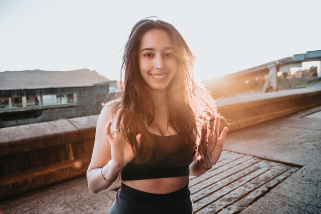 Portrait of young woman during the sunset after doing exercise\
during the sunset smile camera. african berber girl training\
healthy life urban concept. commercial good vibes happiness\
portrait