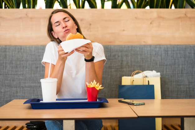 Foto ritratto di giovane donna che mangia fast food