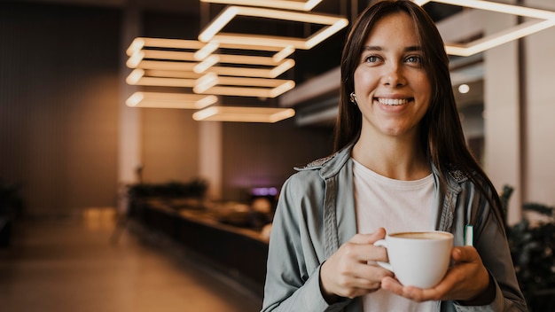 Photo portrait of a young woman enjoying coffee