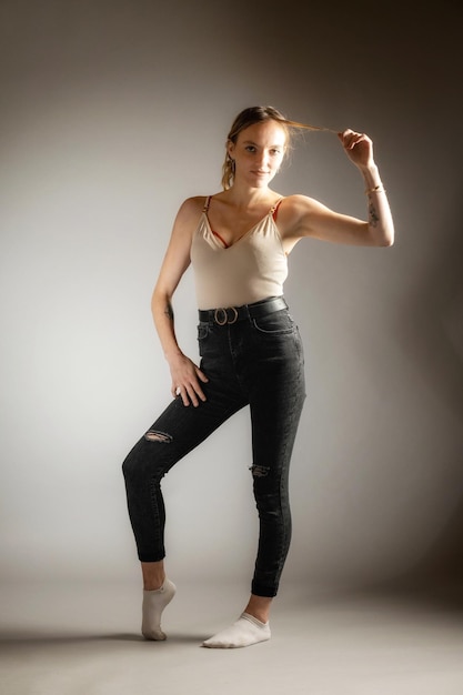 Portrait of young woman exercising against gray background